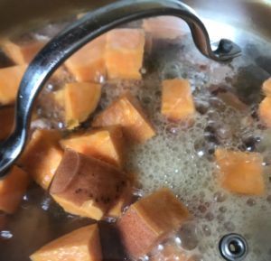 Simmering broth and sweet potato chunks
