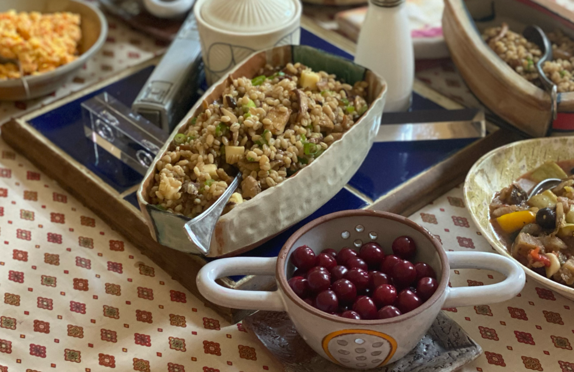 Barley salad with a bowl of cherries in the foreground