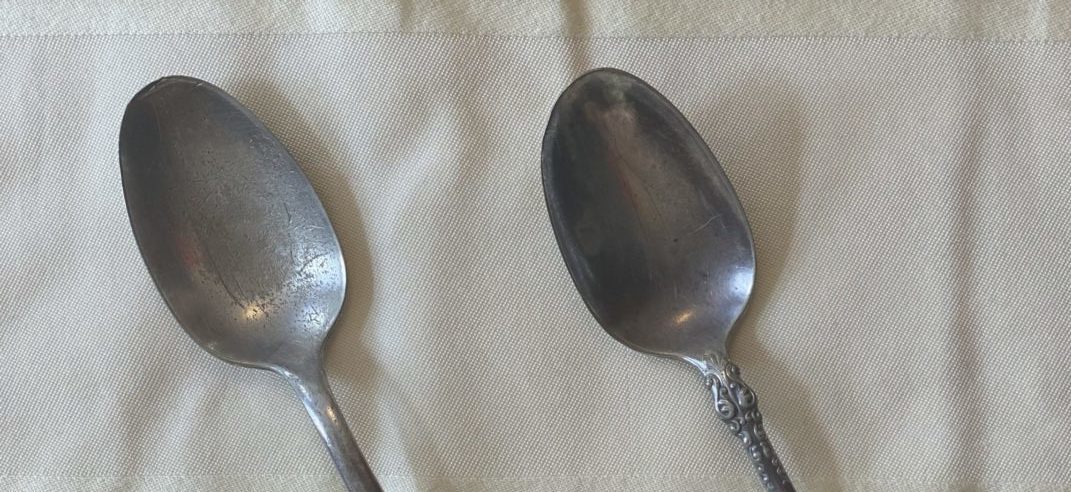 Two silver spoons on a cloth background