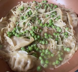 Dumplings with broth, peas, and shredded cabbage